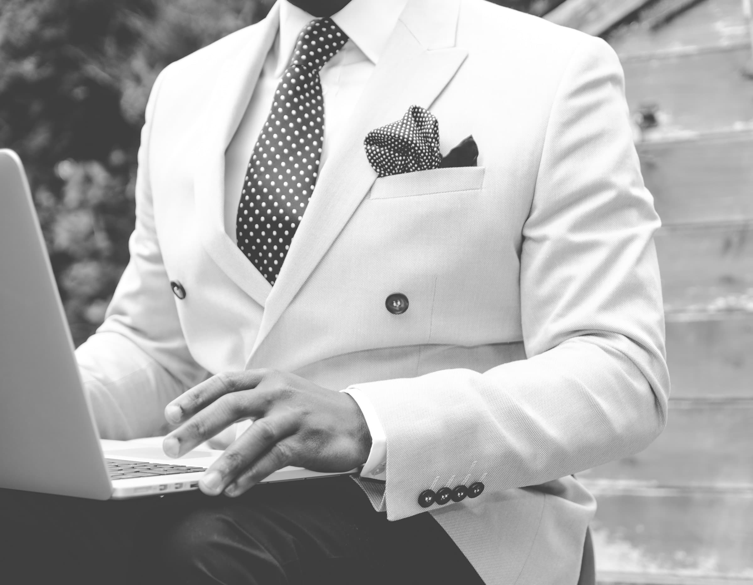 Executive in a tailored suit working on a laptop